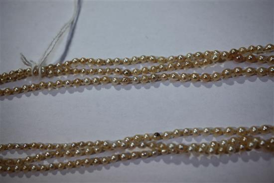 A late 19th/early 20th century triple strand graduated natural pearl necklace with gold, ruby and diamond set oval clasp, 22in.